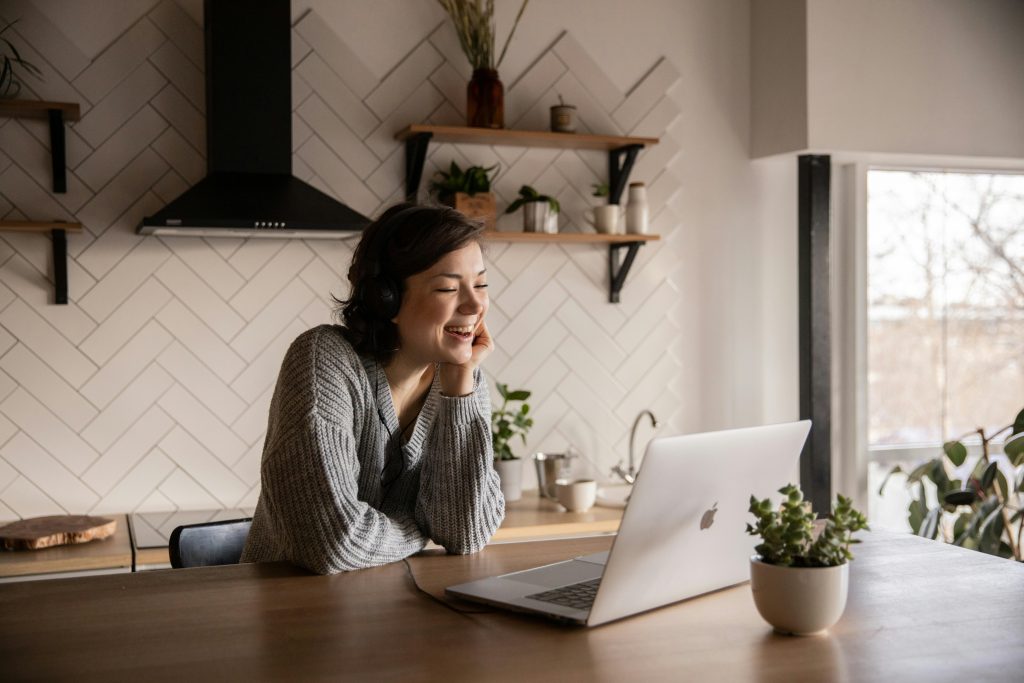 Girl laughing in front of laptop